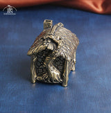 Bronze sculpture of a fairy house on a blue fabric background