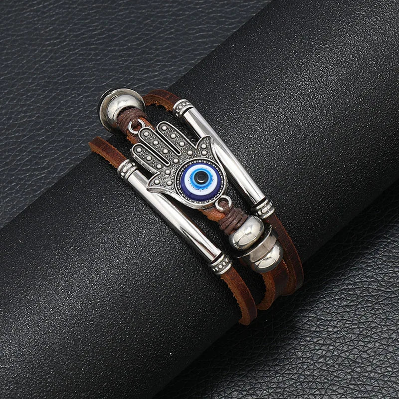 Bracelet with Hamsa hand design and blue eye on a black leather surface