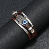 Bracelet with Hamsa hand design and blue eye on a black leather surface
