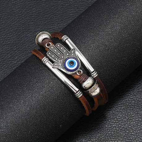 Bracelet with Hamsa hand design and blue eye on a black leather surface