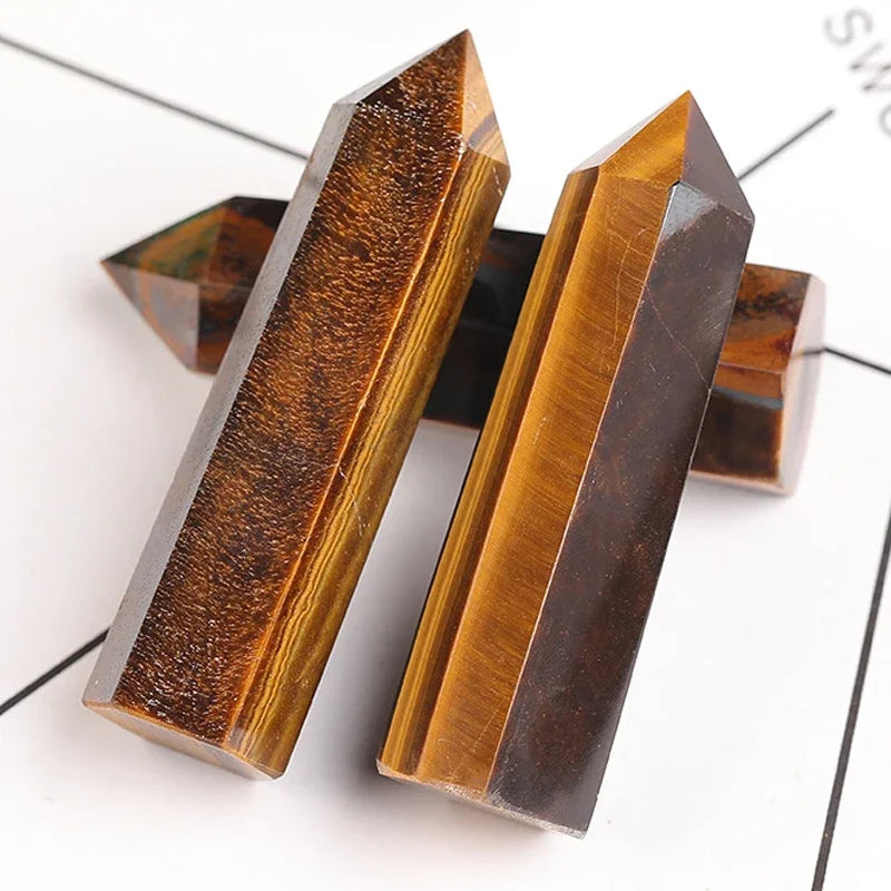 Two tiger eye crystal points on a white background