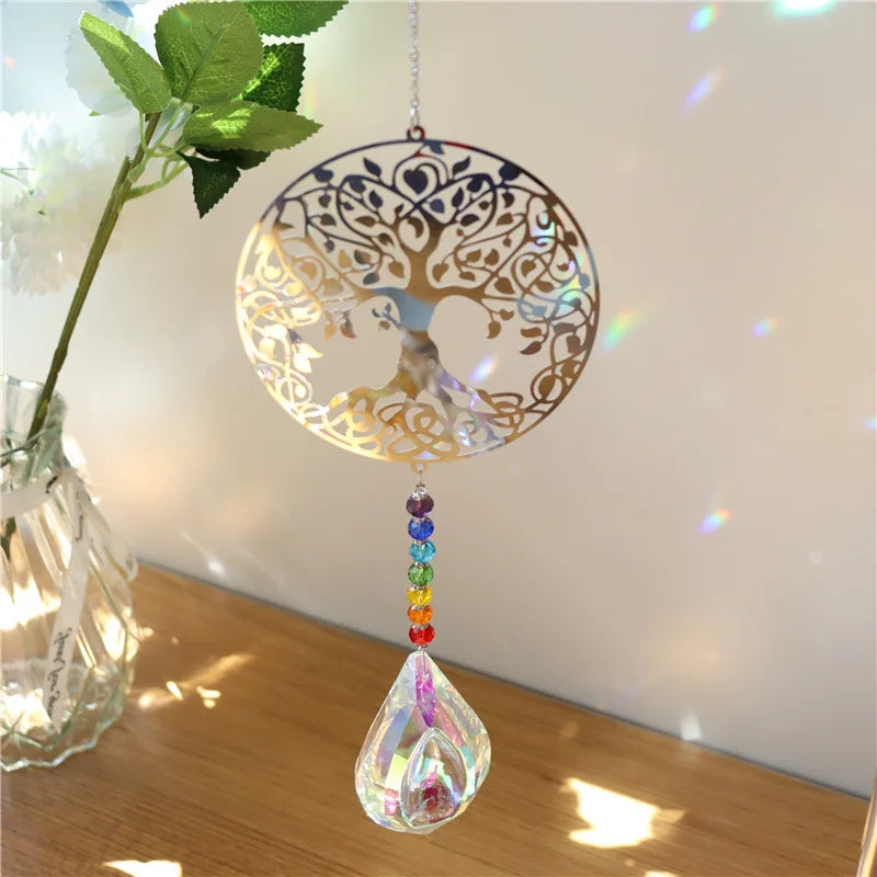 Decorative hanging crystal with tree of life design on a wooden surface.