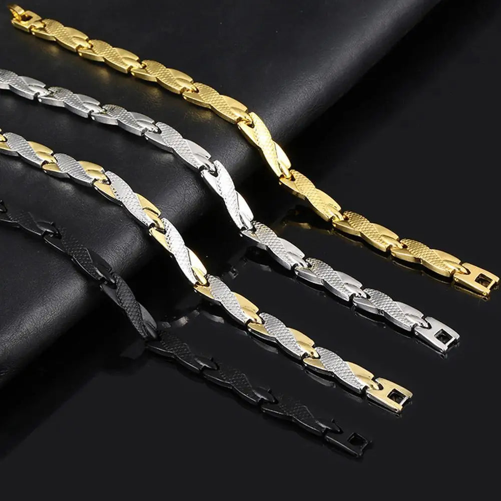 Three gold, silver, and black chain bracelets on a dark surface