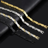 Three gold, silver, and black chain bracelets on a dark surface