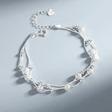 Silver bracelet with floral and bead design on a light gray background