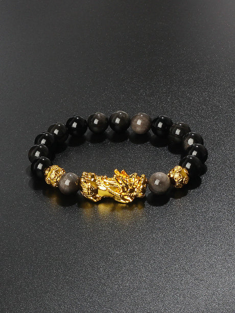 Black beaded bracelet with gold accents on a dark background