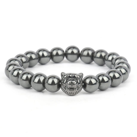 Bracelet with metallic beads and a tiger head charm on a white background