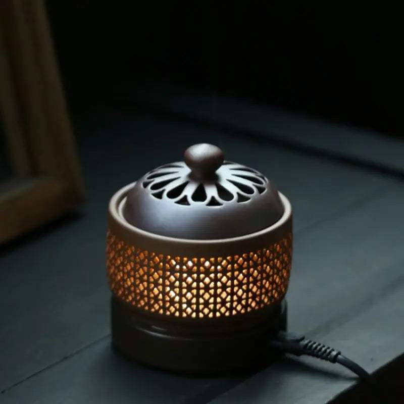 Ceramic incense burner with intricate design on a dark surface