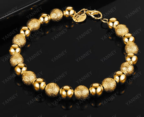 Gold bracelet on a black background with 'YANNEY' branding.