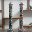 Two ornate incense holders with dragon designs on a wooden surface.