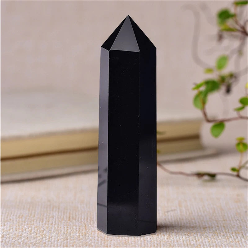 Black crystal pyramid on a textured surface with a blurred background