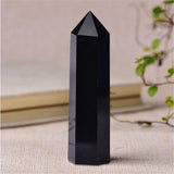 Black crystal pyramid on a textured surface with a blurred background