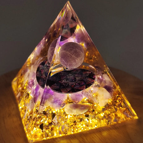 Crystal pyramid with stones on a wooden surface