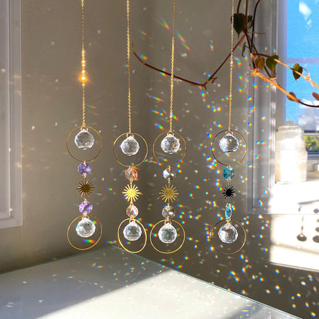 Decorative hanging crystal suncatchers with colorful beads on a reflective surface.