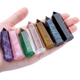 Hand holding a row of colorful crystal points on a white background