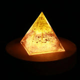 Pyramid-shaped light emitting a warm glow on a dark background