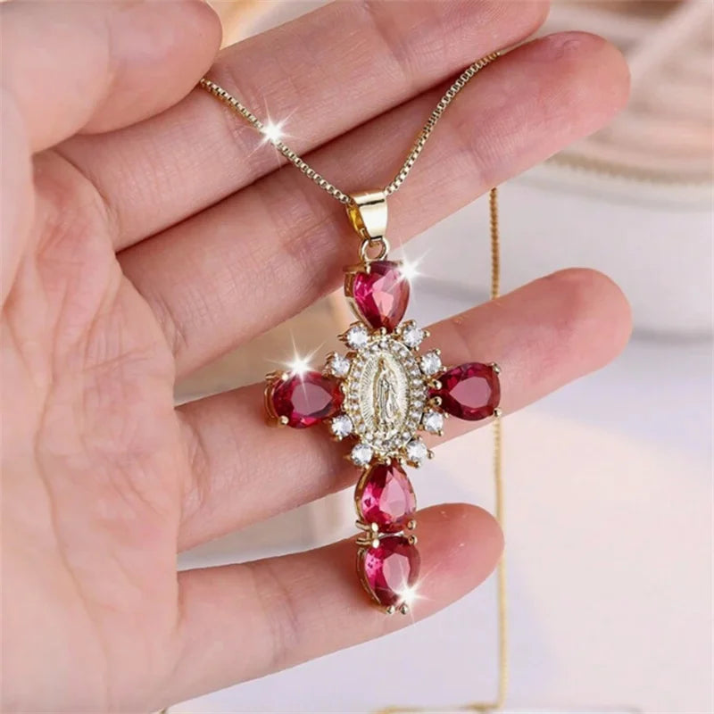 Gold necklace with red gemstones held in a hand against a blurred background