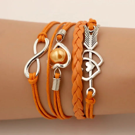 Orange leather bracelets with silver charms on a wrist against a beige background