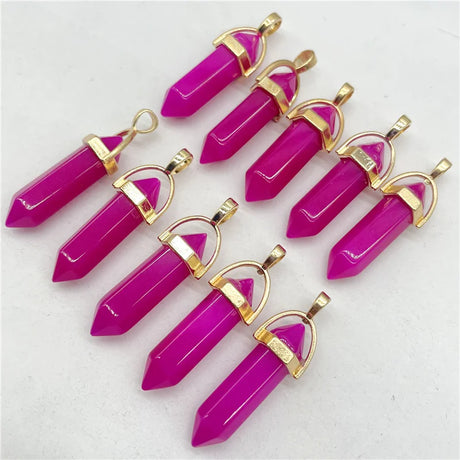 Pink crystal pendants with gold accents on a white background