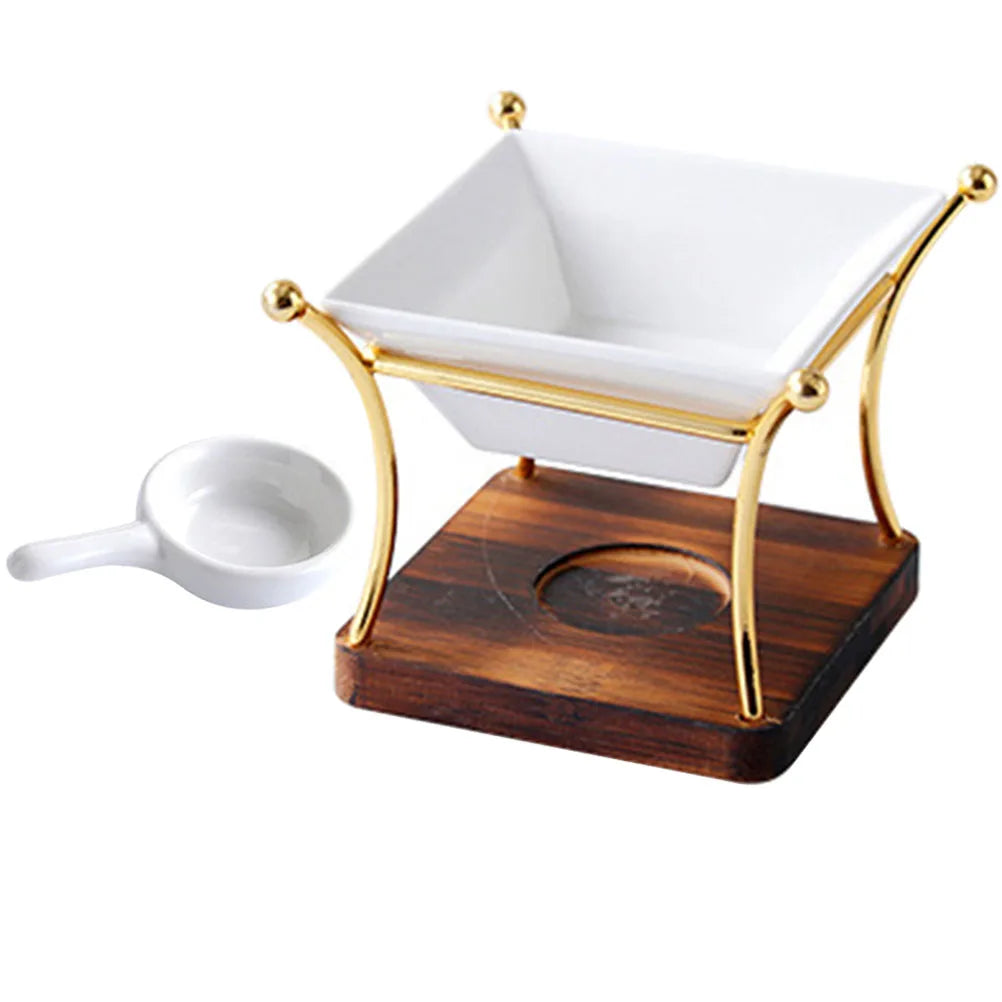White ceramic bowl with gold rim on a wooden stand with a small white scoop, on a white background