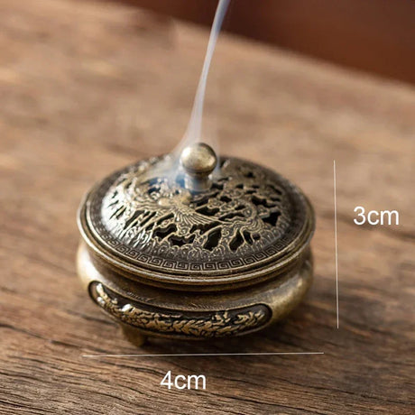 Bronze incense burner with incense stick on a wooden surface, showing dimensions.