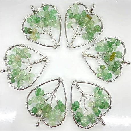 Five green gemstone pendants in silver wireframe designs on a white background