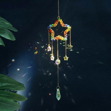 Colorful star-shaped hanging ornament with raindrop design on a dark background