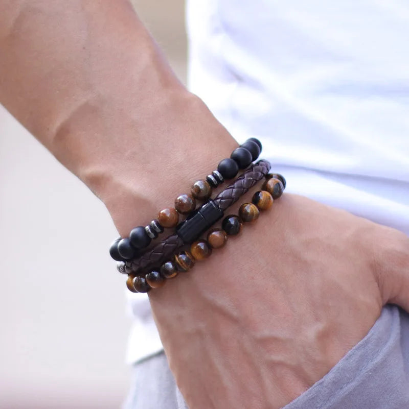 Close-up of a wrist wearing multiple beaded bracelets on a neutral background