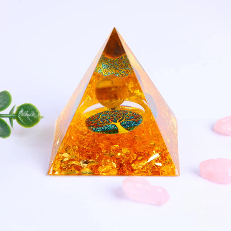 Pyramid-shaped crystal with tree of life design on a light background