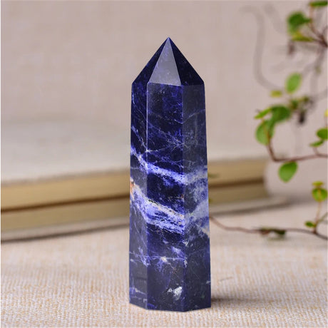 Blue crystal tower on a textured surface with a blurred background