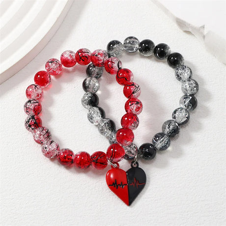 Set of three beaded bracelets with heart charms on a white background