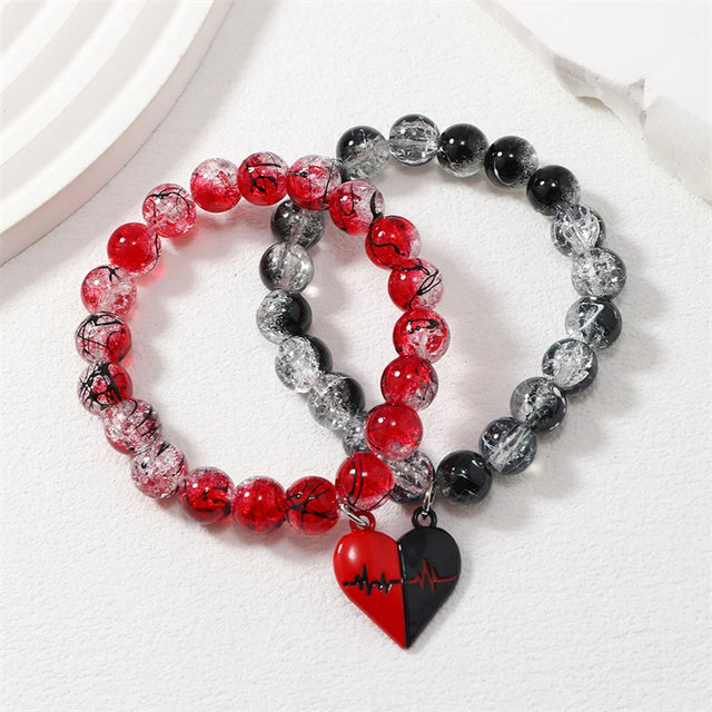 Set of three beaded bracelets with heart charms on a white background