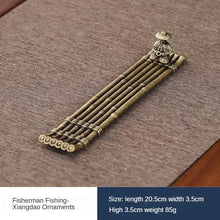 Bronze fisherman ornament on a textured surface with product details.
