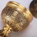 Decorative gold object with intricate patterns on a white background