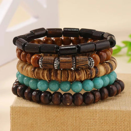 Stack of wooden and beaded bracelets on a textured surface