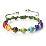 Multicolored beaded bracelet with a green cord on a white background