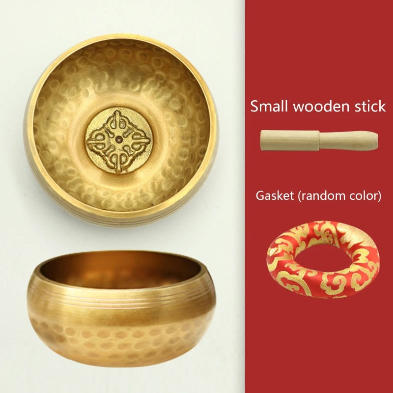 Gold singing bowl set with a small wooden stick and gasket on a white background