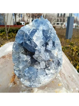 Crystal geode with blue and white crystals on a blurred outdoor background