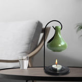 Modern table lamp with a green ceramic shade on a wooden surface.