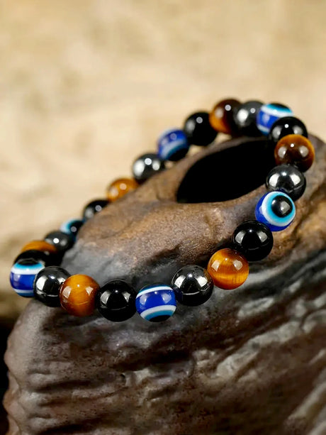 Multicolored beaded bracelet on a stone surface with a blurred natural background