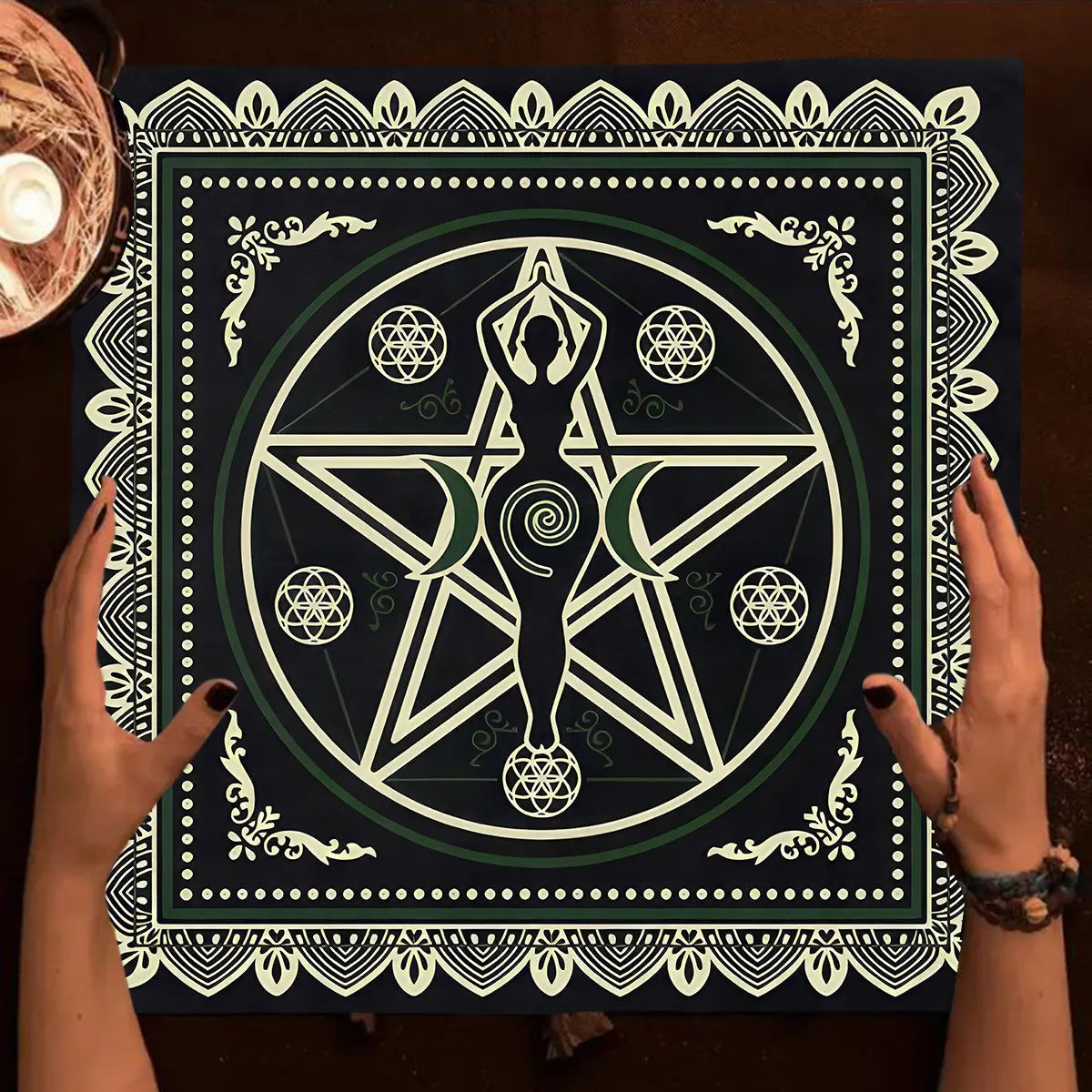 Person holding a black and white symbol poster with hands on a wooden surface.