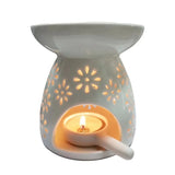 Ceramic wax warmer with floral cutout design on a white background