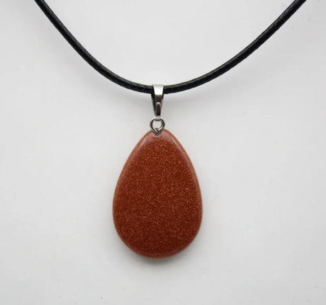 Brown teardrop pendant on a black cord against a white background
