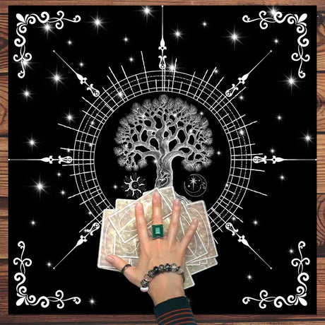 Hand holding tarot cards with a tree of life symbol on a decorative background
