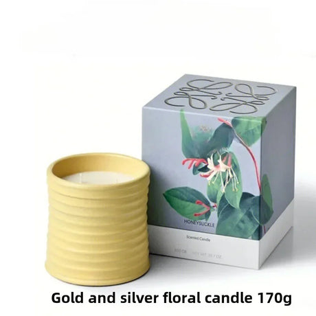 Gold and silver floral candle with packaging on a white background