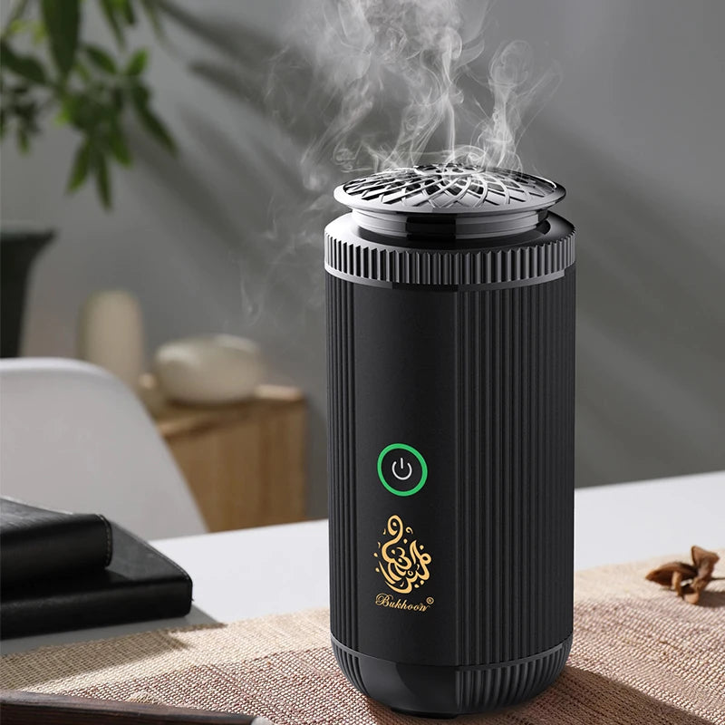 Black essential oil diffuser with steam on a table with a blurred background