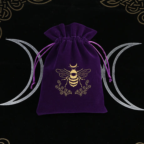 Purple velvet drawstring bag with bee design on a black background with moon phases.