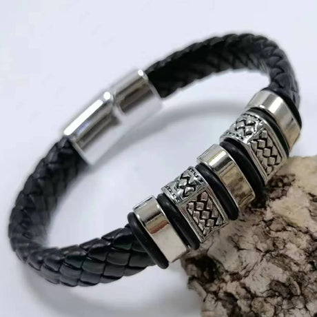 Black braided leather bracelet with silver metal beads on a white background