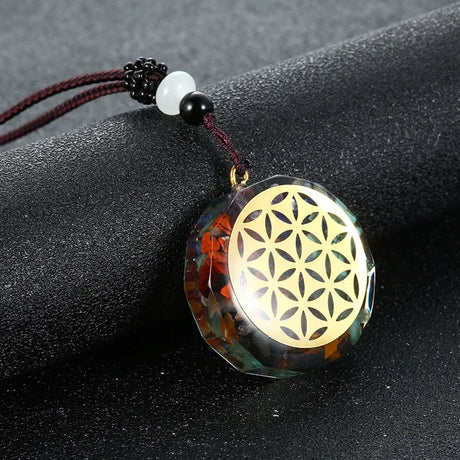 Pendant with Flower of Life design on a dark surface