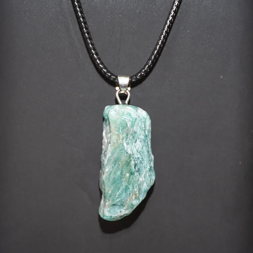 Turquoise stone pendant on a black cord against a dark background